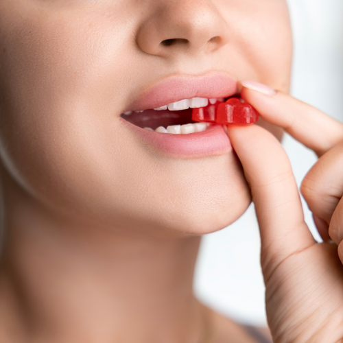 A close up of woman biting into a red energy chew.