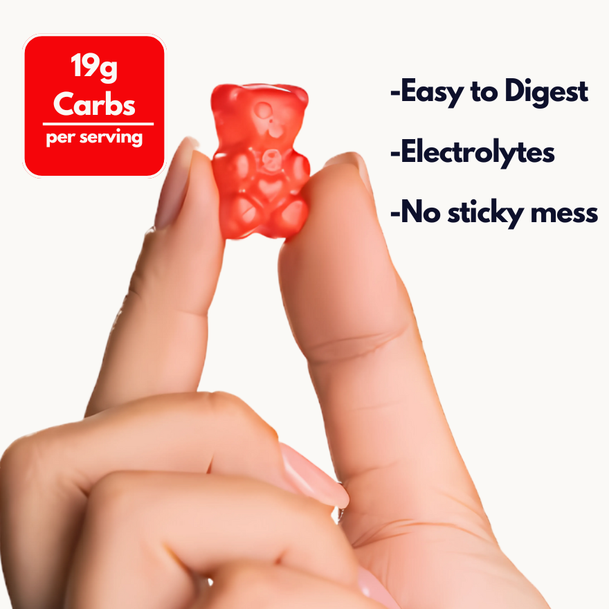 A close up of a hand holding a single fruit smoothie intrachew energy chew performance gummy bear between two fingers against a white background with text that explains the benefits versus energy gels.